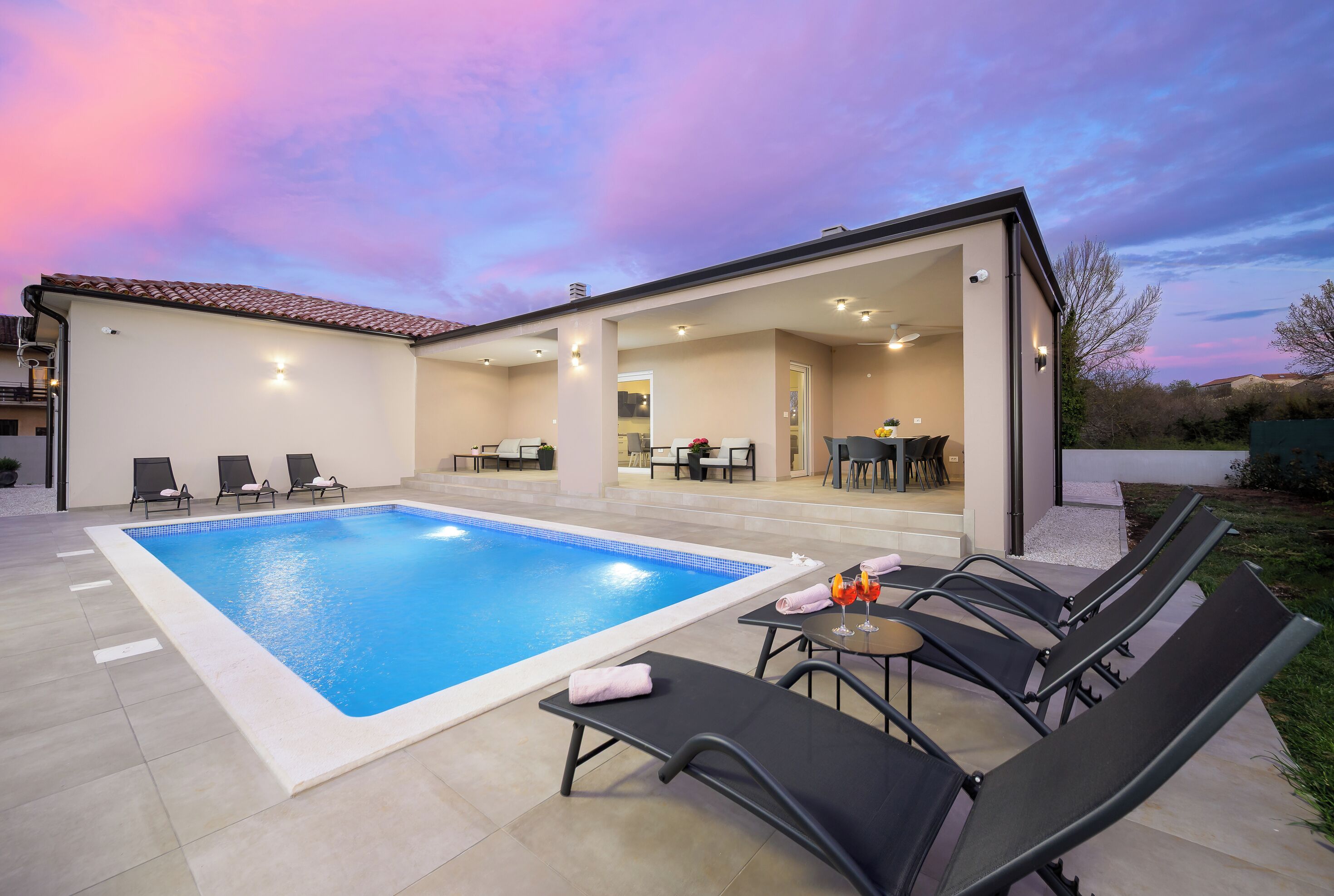 Ein Swimmingpool mit Liegestühlen und einer Terrassenanlage.