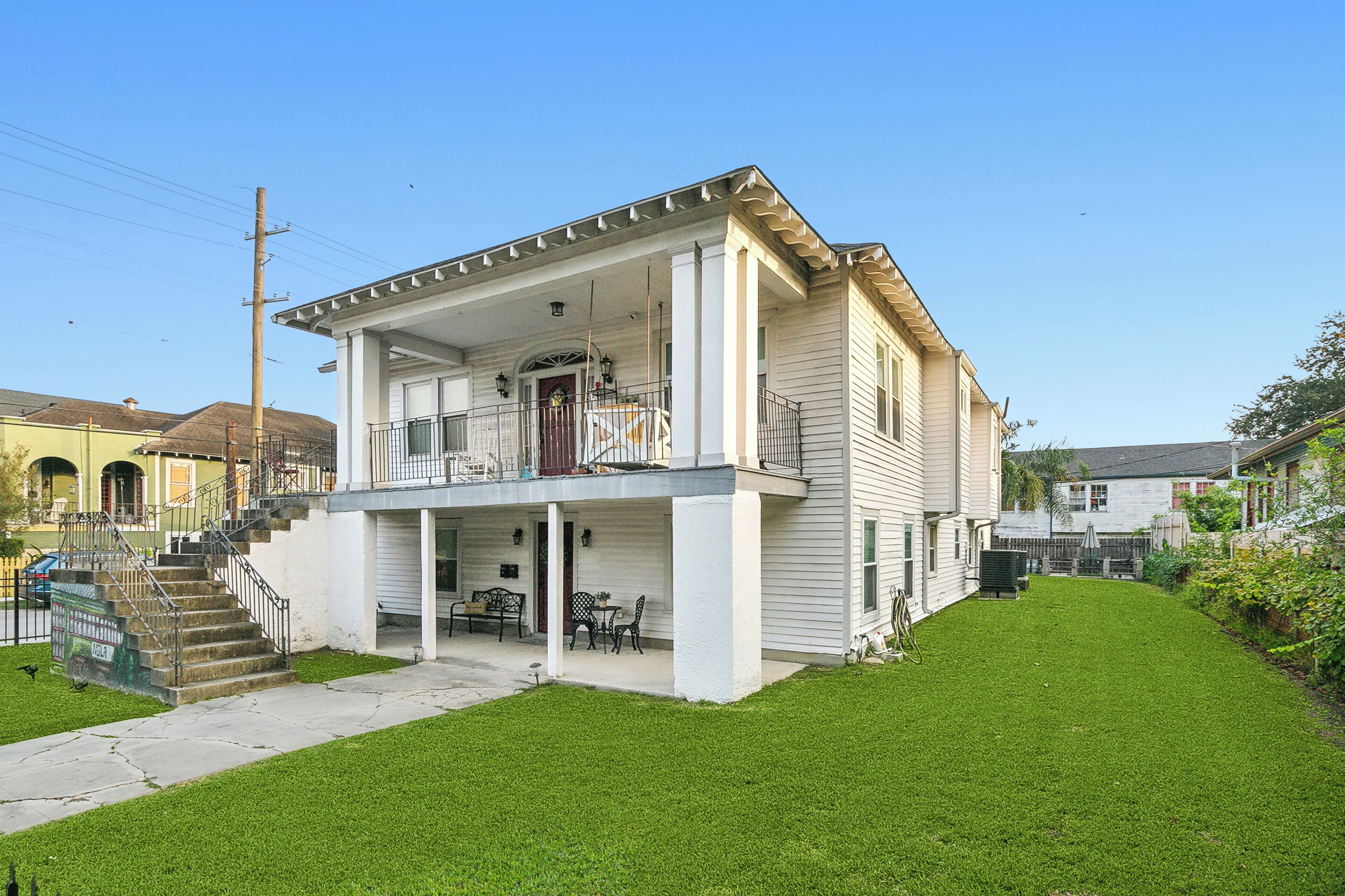A two-story house with a front porch, a staircase, and a small front yard.
