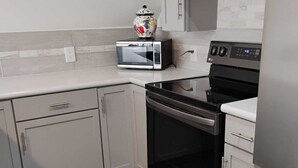 A kitchen with a microwave, oven, and refrigerator. - Quiet Waterfront Getaway Private Escape 1BR Apt Retreat with Optional Boat Dock (Stevensville)