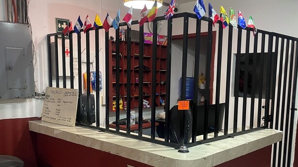 Una recepción con un cartel, una lámpara estampada y una hilera de banderas.