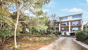 A multi-story building with balconies, a paved pathway, and surrounding greenery. - Moderne villa piscine (Argelès-sur-Mer)