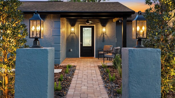 A house with a brick pathway leading to a door, flanked by two lantern-style lights. - Eternity Wellness Retreat Jacuzzi/Sauna/ColdPlunge (Tampa)