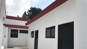 A building with a red roof, white walls, and black doors and windows.