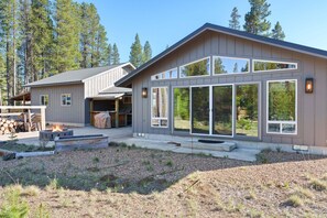 A modern house with a large garage, a fire pit, and a well-maintained yard.