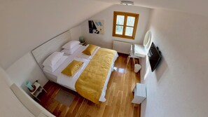 A bedroom with a bed, bedside table, radiator, and a window. - Relaxing countryside escape with pool, sauna and homemade delights (Čazma)
