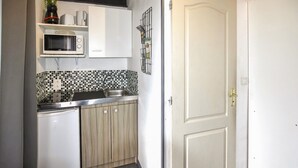 A compact kitchen with a microwave, sink, and wooden cabinets. - Amazing home in Taillades with outdoor swimming pool (Taillades)