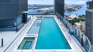 A rooftop pool with a view of a cityscape and a body of water. - Luxury High-Rise 1BR in Downtown Miami (Miami)