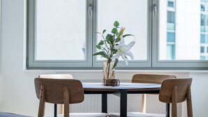 En matplats med ett bord, stolar och ett fönster med utsikt över byggnader.
