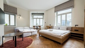 Ett modernt sovrum med en säng, en soffa, ett litet bord och ett skrivbord.