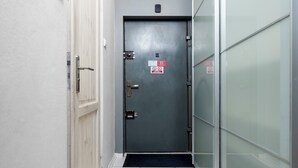 Un pasillo con una puerta gris, una blanca y una de vidrio.