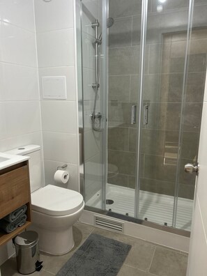 Een haardroger, handdoeken, zeep, toiletpapier