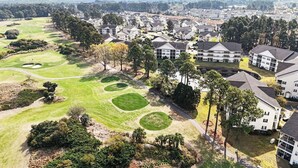 A residential area with houses, a golf course, and a large building with multiple floors. - Tee Time Retreat- Pool Access + Premier Golf (Myrtle Beach)