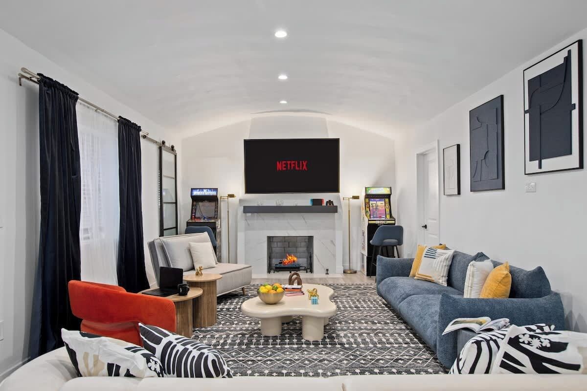 Ein modernes Wohnzimmer mit Kamin, Flachbildfernseher und einer Couch.