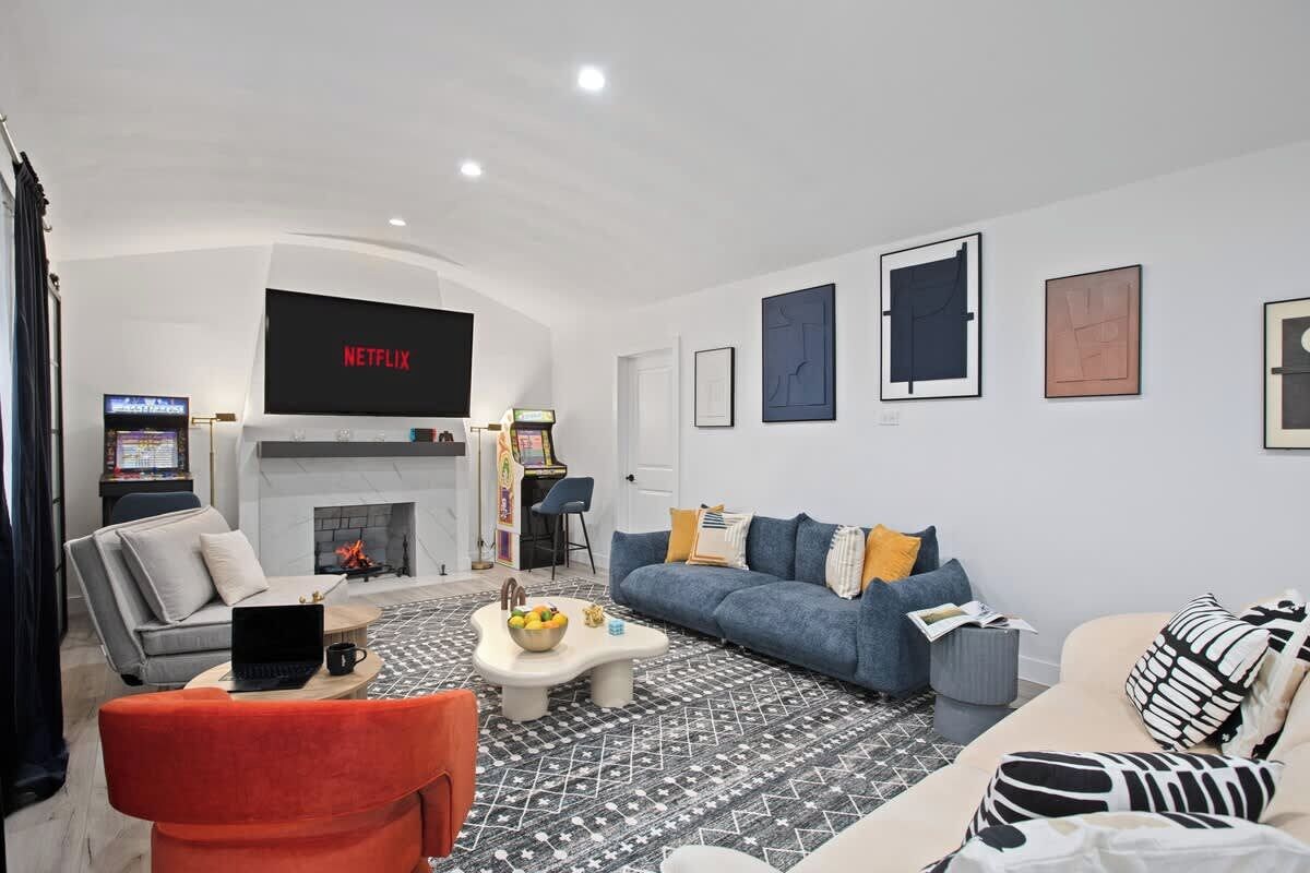A modern living room with a fireplace, a sofa, a coffee table, and a television displaying 'NETFLIX'.
