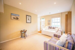A room with a beige carpet, a white sofa, a striped couch, and two framed artworks on the wall. - North Warren Cottage, Aldeburgh (Aldeburgh)