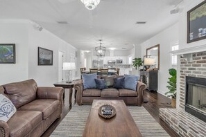 Ein Wohnzimmer mit braunem Ledersofa, einem Holztisch und einem Kamin.