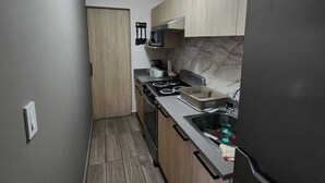 Una cocina con estufa, microondas y refrigerador.