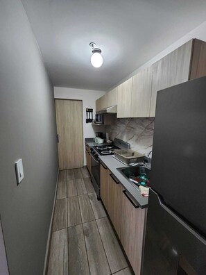 Eine Küche mit Herd, Mikrowelle und Kühlschrank.