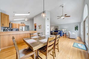 A spacious kitchen with wooden cabinets, a dining table with chairs, and a bar area.