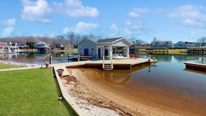 Une propriété au bord du lac, dotée d’un quai, d’une petite maison et d’un espace aménagé pour la baignade.