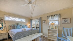 A bedroom with a bed, bench, dresser, chair, and a ceiling fan. - Cottage at the Lake - Waterfront lake-view home with dock, fireplace, pool table, kayaks, & firepit (Moneta)