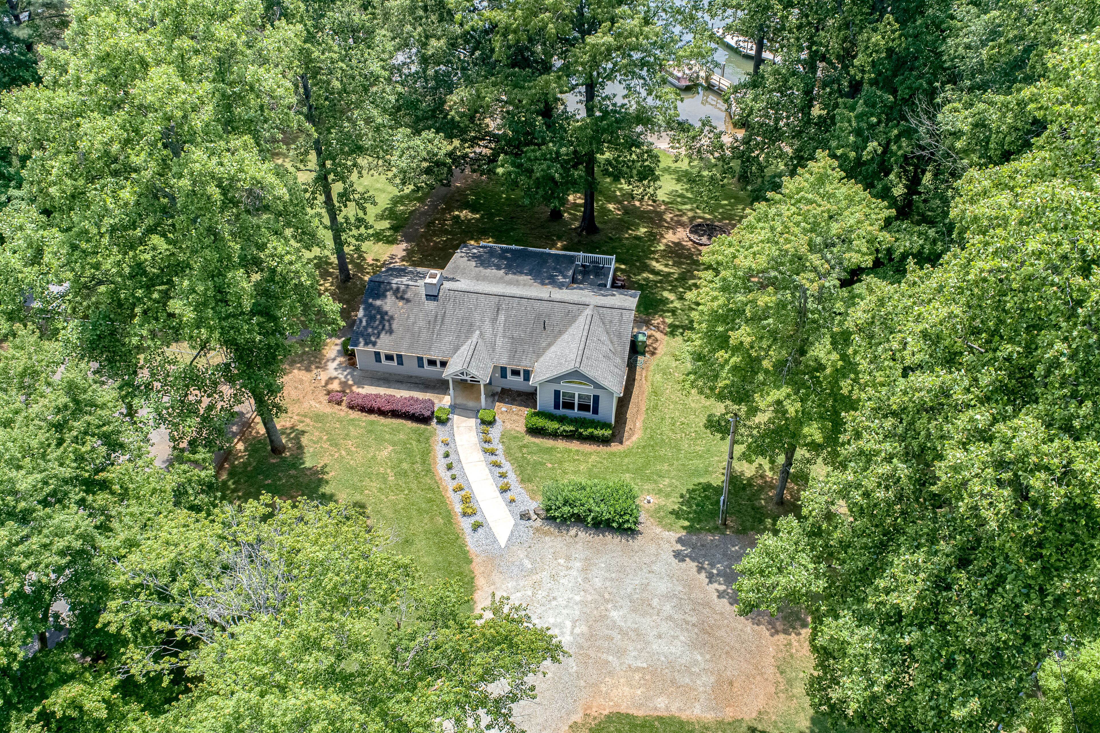 An aerial view of a house surrounded by dense green trees.