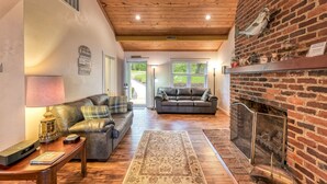 Ein gemütliches Wohnzimmer mit Kamin, Ledersofas und Holzboden.