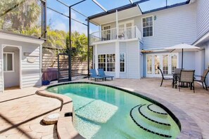 A residential property with a swimming pool, outdoor seating, and a covered patio area. - NEW! Heron Lagoon Hideaway: Canal Front, Pool, Dog (Sarasota)