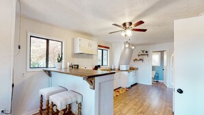 A kitchen with a wooden island, white cabinetry, and a ceiling fan. - Dock Sun Point - Lakefront home for easy boating, fishing, private dock & AC/Wifi, Dogs ok! (Huddleston)