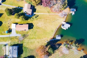 An aerial view of a residential area with houses, a dock, and a body of water.