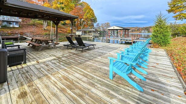 Une terrasse en bois avec des sièges extérieurs et une vue sur un lac.