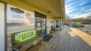 A coffeehouse with a wooden deck, a bench, and a signboard listing awards.