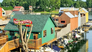 Une propriété située au bord de l’eau, dotée d’un bâtiment écologique portant l’inscription « Harbor Town Golf », de quais en bois et de bateaux.