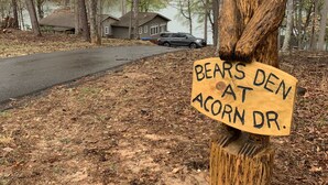 A wooden bear sculpture holding a sign that reads "BEARS DEN AT ACORN DR." - Bears Den at Acorn Dr - Spacious pet friendly Cottage with balcony, dock, and hot tub (Moneta)