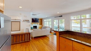 A modern kitchen with wooden flooring, a built-in oven, and a large window. - Bears Den at Acorn Dr - Spacious pet friendly Cottage with balcony, dock, and hot tub (Moneta)