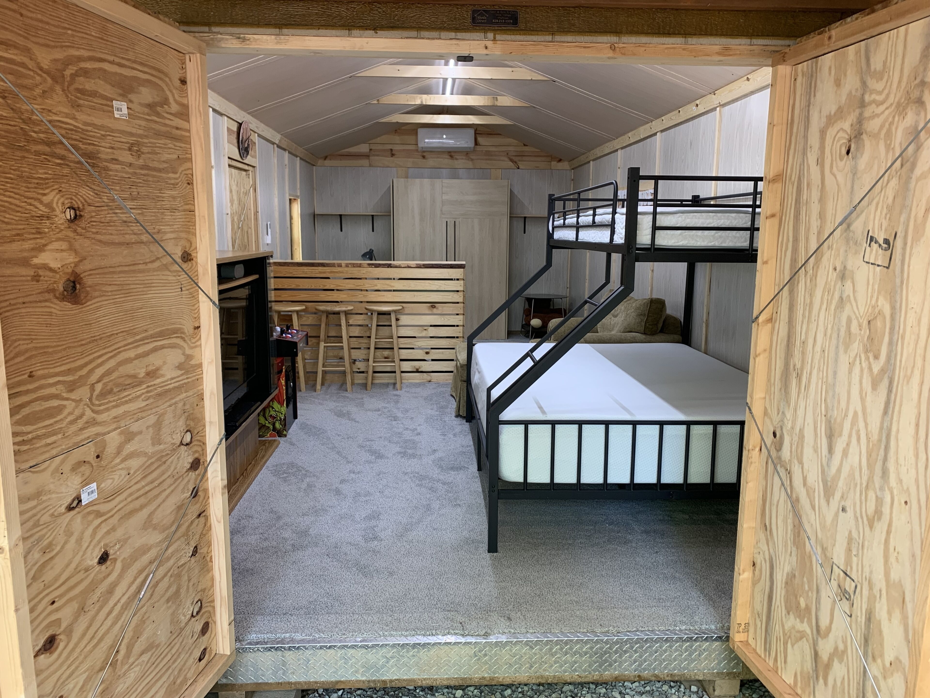 A compact, wooden interior with bunk beds, a small kitchenette, and a bar area.