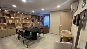 Ein moderner Essbereich mit einem runden Tisch, Stühlen, einem Bücherregal und einem Kühlschrank.