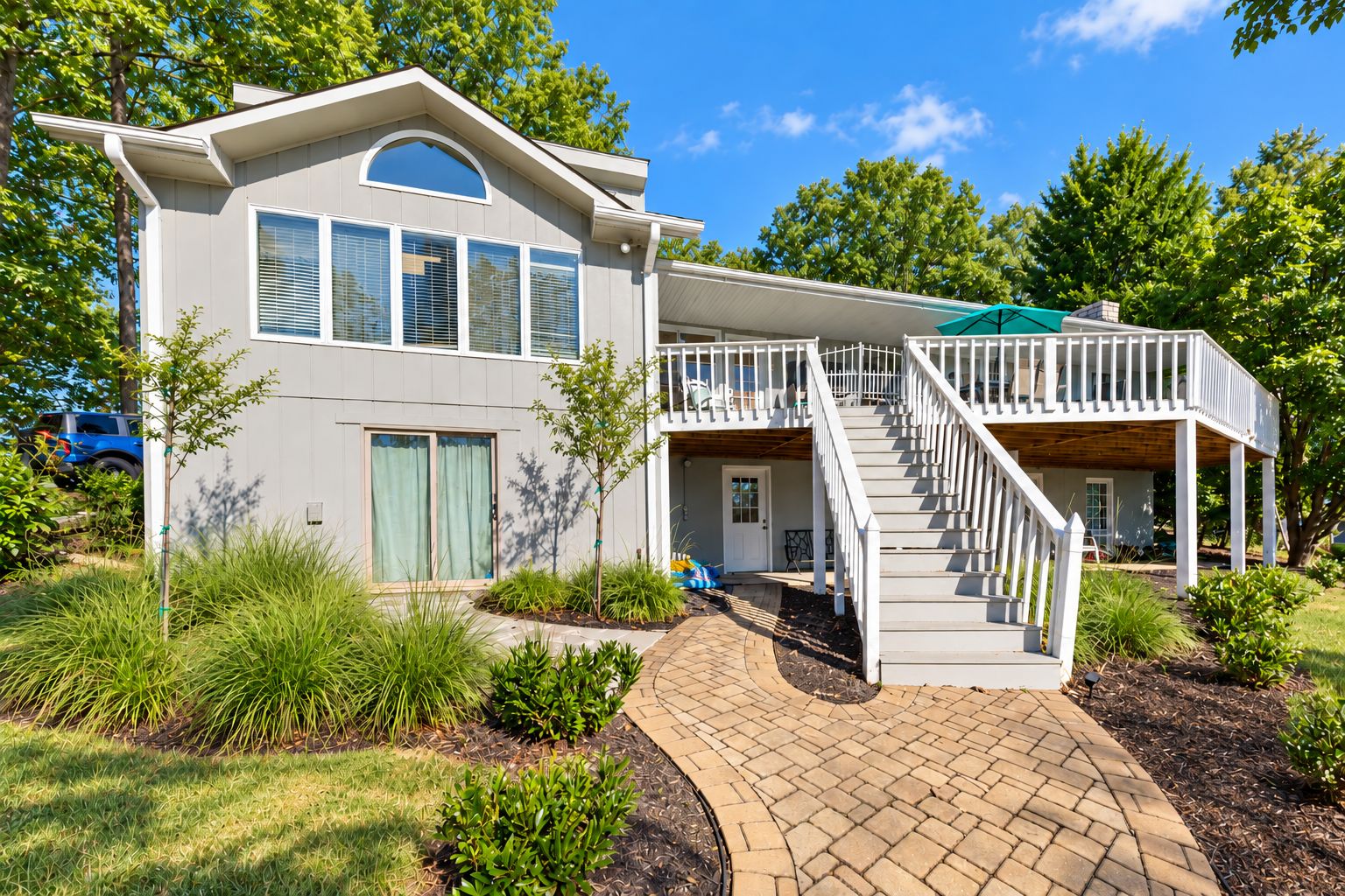 A two-story house with a covered porch and a staircase leading to the upper level.