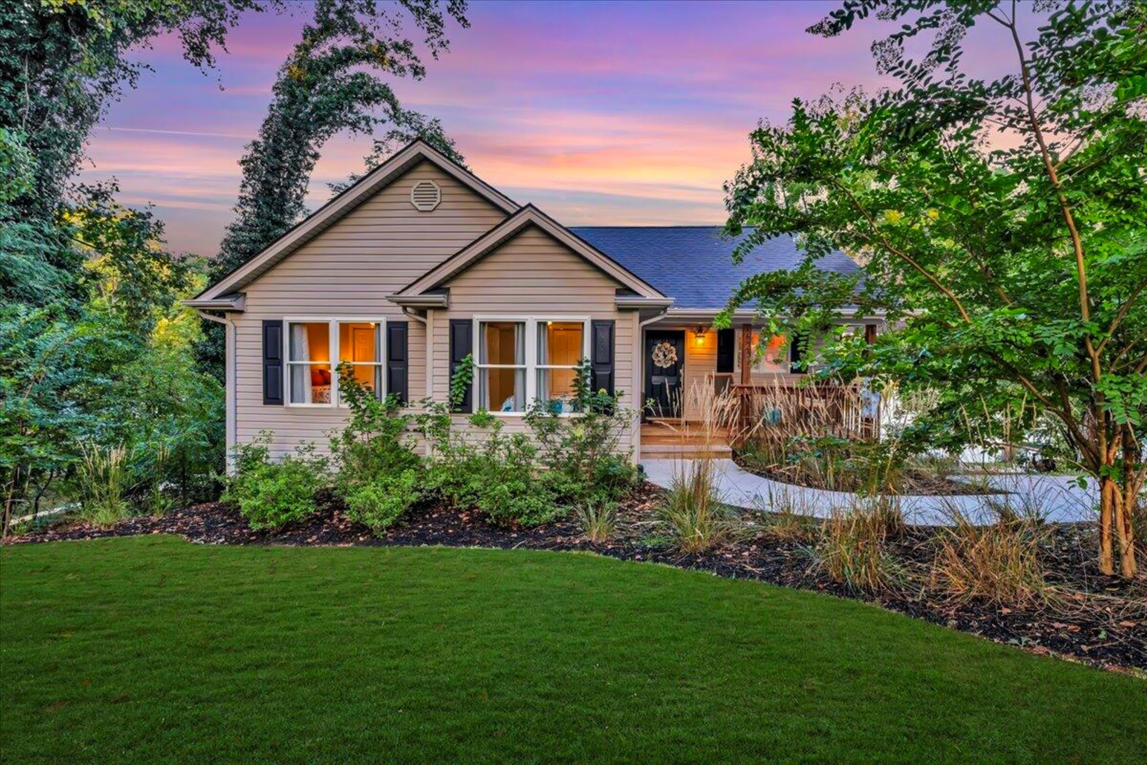 A two-story house with a well-maintained lawn and a deck.
