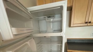 Ein offener Kühlschrank mit mehreren Einlegeböden und einem Gefrierfach.