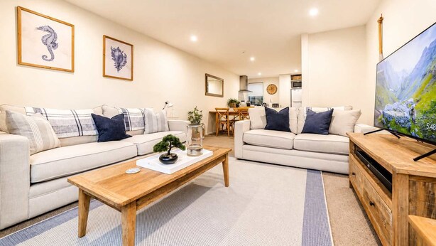 A modern living room with two sofas, a coffee table, and a TV. - Salisbury Garden | 2BR with Parking | CBD (Christchurch)