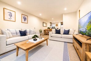 A modern living room with two sofas, a coffee table, and a TV.