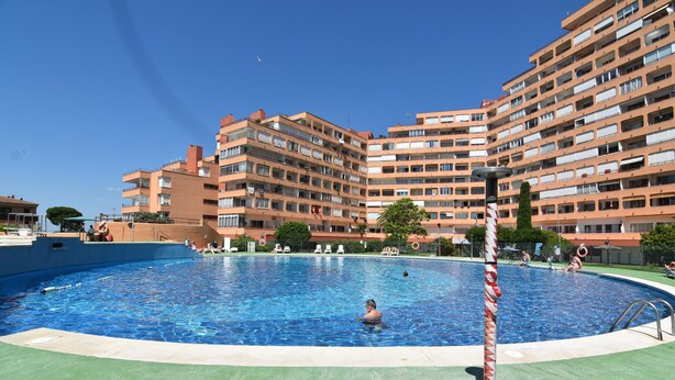 A swimming pool surrounded by multi-story residential buildings. - Discover this charming studio located in Santa Margarita, Roses! (Roses)