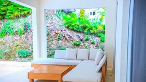 Una camera moderna con un'ampia finestra, una panca in legno e un divano bianco.