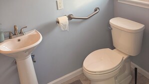 Ein Badezimmer mit Waschbecken, Toilette und Spiegel.