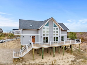 A two-story house with a balcony, a front door, and a staircase leading to the upper level.