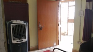 A room with a radiator, a door, a window, and a chair. - Superb 1-bedroom studio in vibrant Vrindavan for your stay near Iskcon Vrindavan (Vrindavan)