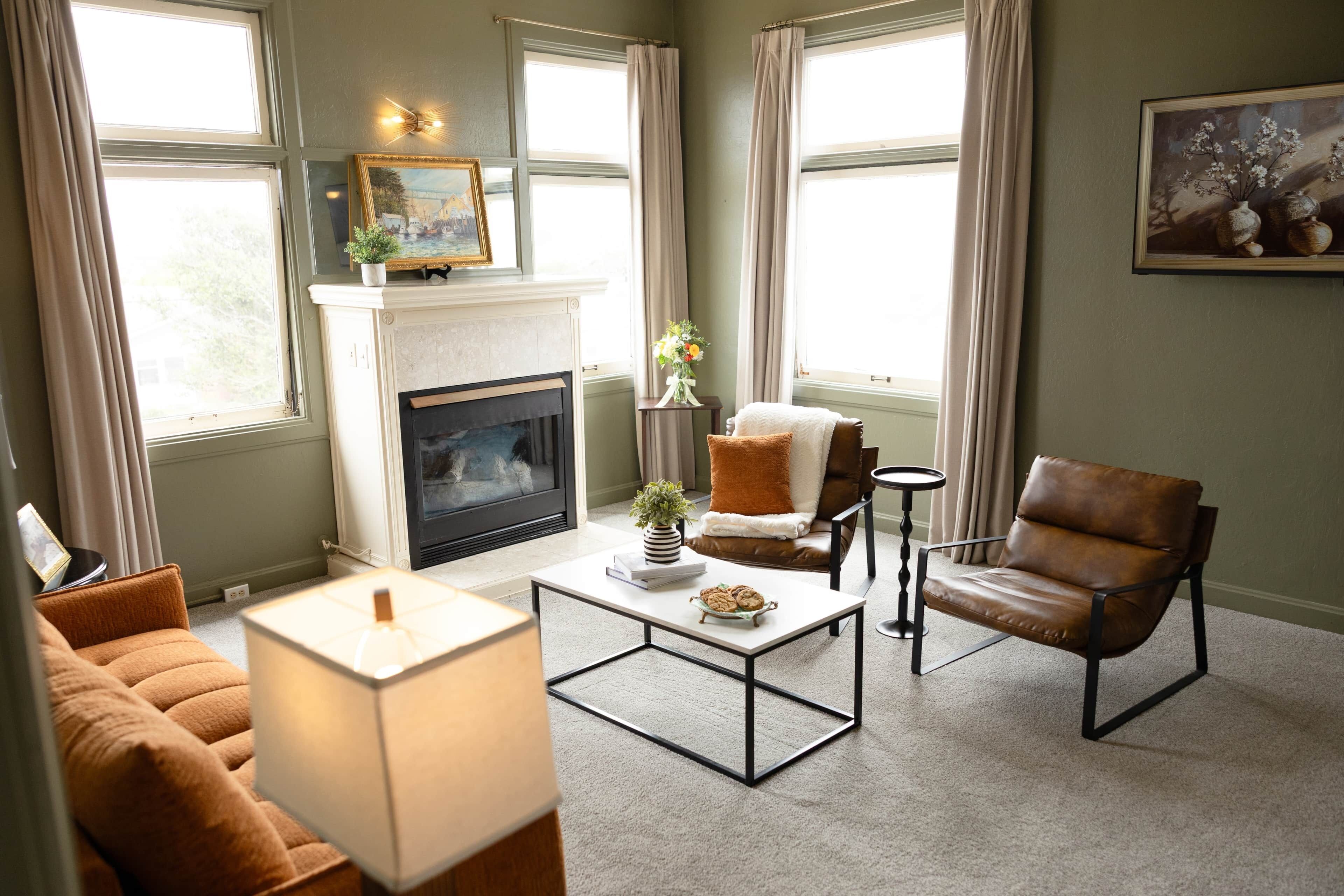 Un salon avec une cheminée, un canapé, une table basse et un fauteuil.