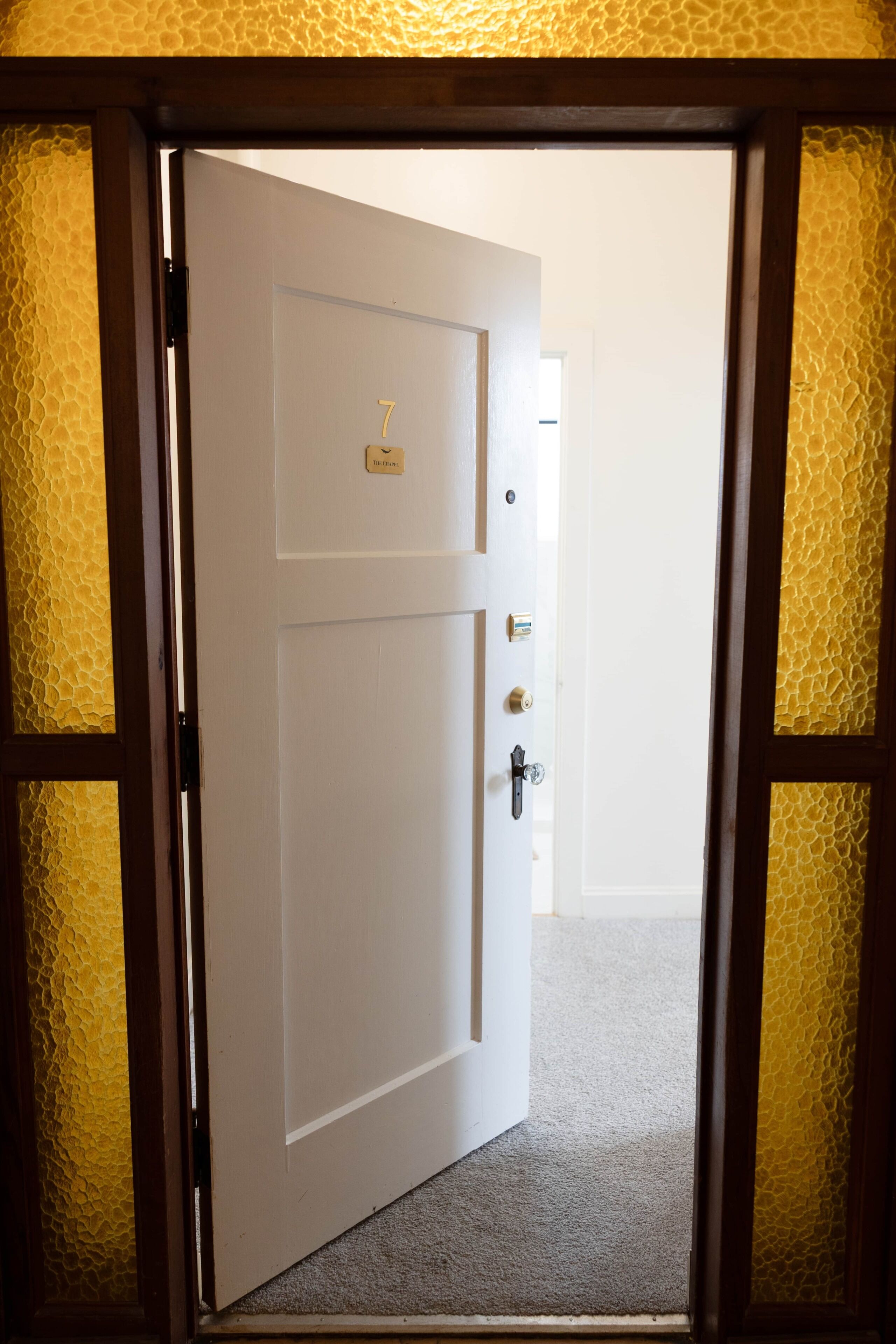 Puerta cerrada con placa, mirilla y cerradura.