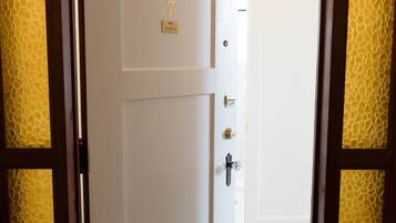Puerta cerrada con placa, mirilla y cerradura.